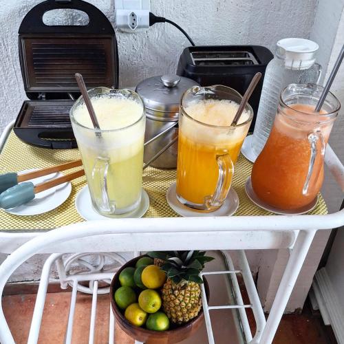 uma prateleira com três bebidas e uma tigela de frutas em Porto Mar de Búzios em Búzios