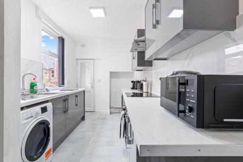a kitchen with a washer and dryer on a counter at Leicester Central 4BR Home - Garden - Sleeps 10 in Leicester