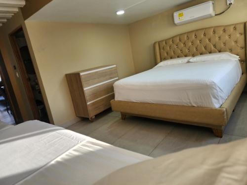 a bedroom with two beds and a headboard at Hotel y Cabañas Covemar in Coveñas