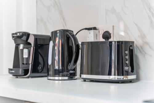 three coffeemakers sitting on a kitchen counter at Leicester Central 4BR Home - Garden - Sleeps 10 in Leicester