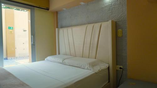 a small bed in a room with a window at Hotel y Cabañas Covemar in Coveñas