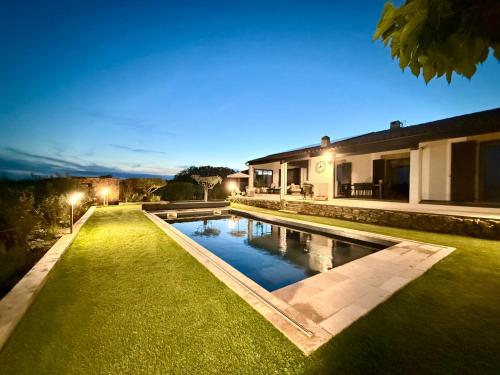 a swimming pool in front of a house at night at Une nuit en Luberon in Puyvert