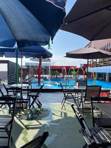 a group of tables and chairs with umbrellas next to a pool at Pousada Tapary Beach in Santarém