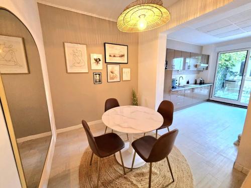 a dining room with a table and chairs and a kitchen at Havre de Paix - Les Sablon d'A Côté in Amiens