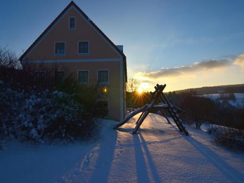 a camera in the snow in front of a house at Spacious Apartment in Schönsee with Sauna in Dietersdorf