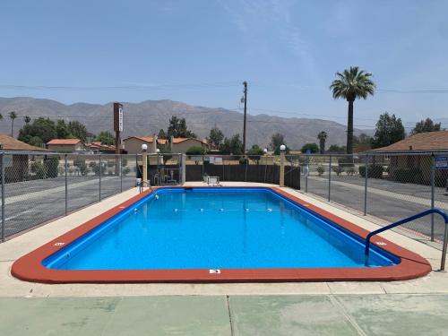 a large swimming pool with blue water at Hacienda Motel in San Jacinto