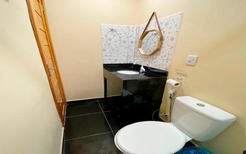 a bathroom with a white toilet and a sink at Pousada Tapary Beach in Santarém