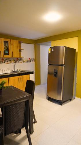 a kitchen with a stainless steel refrigerator next to a table at Hotel y Cabañas Covemar in Coveñas