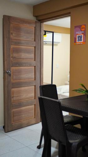 a dining room with a wooden door and a table and chairs at Hotel y Cabañas Covemar in Coveñas