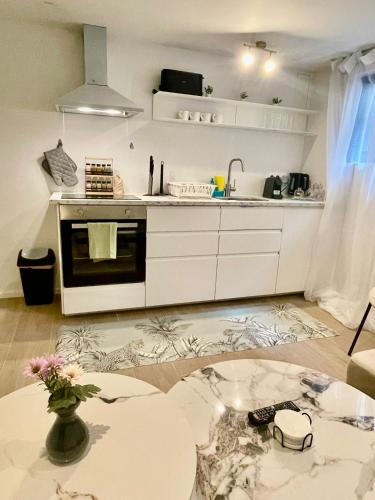 a kitchen with white cabinets and a table in a room at One Lux Stay Studio Basement near Antwerp Central in Antwerp