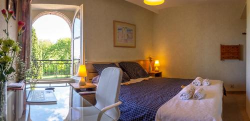 a bedroom with a bed and a desk and a window at Lacoume Saint Jacques in Auch