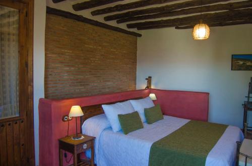a bedroom with a bed and a brick wall at Casa Núm 8 in Válor