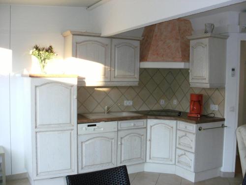 une cuisine avec des armoires blanches et un appareil rouge dans l'établissement Villa CLASSIC - Port Nature VPN30 - 2 personnes, au Cap d'Agde