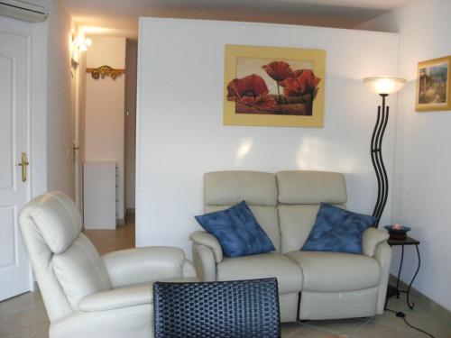 - un salon avec un canapé blanc et des oreillers bleus dans l'établissement Villa CLASSIC - Port Nature VPN30 - 2 personnes, au Cap d'Agde