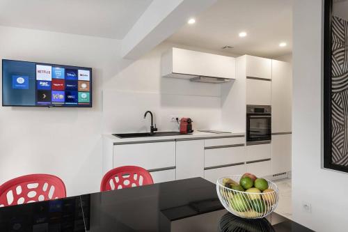 - une cuisine avec un bol de pommes sur un comptoir dans l'établissement Villa SWING - Port Nature VPN50 - Luxe - 2 personnes, au Cap d'Agde