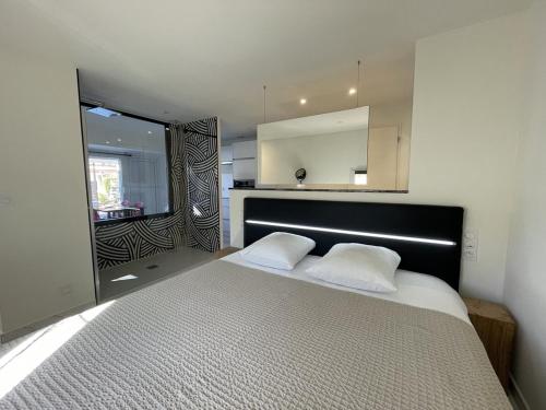 une chambre avec un grand lit et un grand miroir dans l'établissement Villa SWING - Port Nature VPN50 - Luxe - 2 personnes, au Cap d'Agde