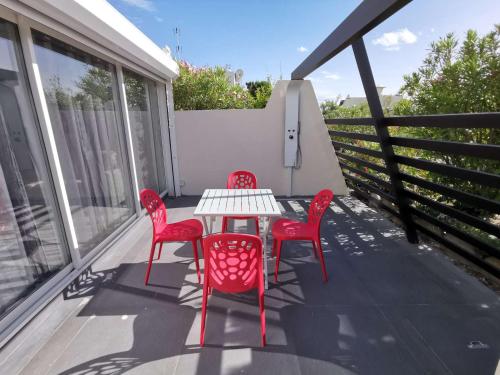d'une terrasse avec des chaises rouges et une table sur un balcon. dans l'établissement Villa SWING - Port Nature VPN50 - Luxe - 2 personnes, au Cap d'Agde