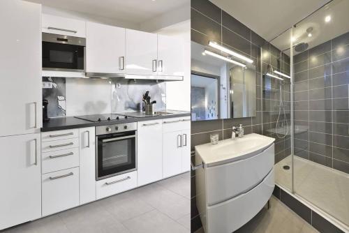 La cuisine est équipée de placards blancs, d'un lavabo et d'une douche. dans l'établissement Villa MORGANN - Port Nature VPN22 - Luxe - 2 personnes, au Cap d'Agde