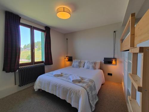 une chambre avec un lit et une grande fenêtre dans l'établissement Petit Mont Blanc Guest House, à Peisey-Nancroix