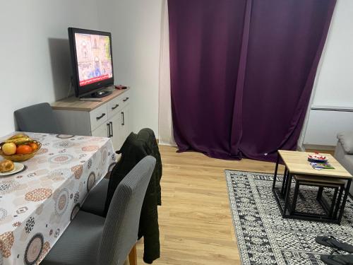 une salle à manger avec une table et une télévision dans l'établissement Bien au calme, à La Celle-sous-Gouzon