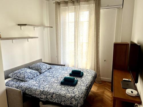 - une chambre avec un lit et 2 serviettes vertes dans l'établissement Lumineux appartement dans le quartier des Fleurs, à Nice