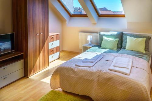 Un dormitorio con una cama grande con toallas. en KLEO Apartman, en Pécs