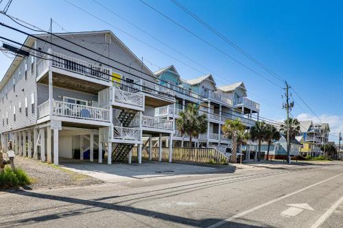 a large white apartment building on the side of a street at Carolina Beach Condo with Deck Steps to Shore! in Carolina Beach