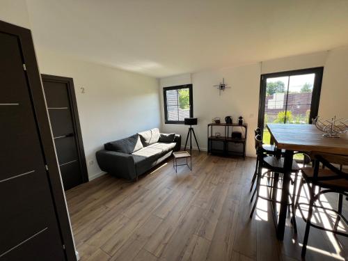 a living room with a couch and a table at la Maison d'à côté Chambre 3 in Cuise-la-Motte