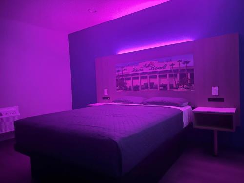 a bedroom with a bed with purple lighting at Hi-Way Host Motel in Pasadena