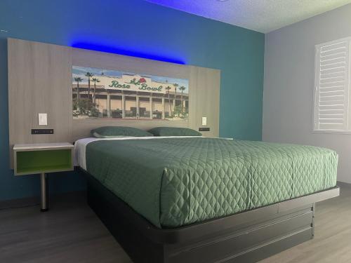 a bedroom with a large bed with a blue ceiling at Hi-Way Host Motel in Pasadena