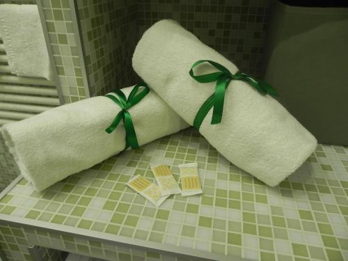 due asciugamani con fiocchi verdi su un bancone in un bagno di Hakuna Matata B&B a Pescara