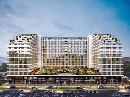 two tall white buildings with cars parked in a parking lot at Planet Residence NiNa in Niš
