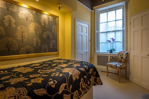a bedroom with a bed and a window and a chair at The George Hotel of Stamford in Stamford