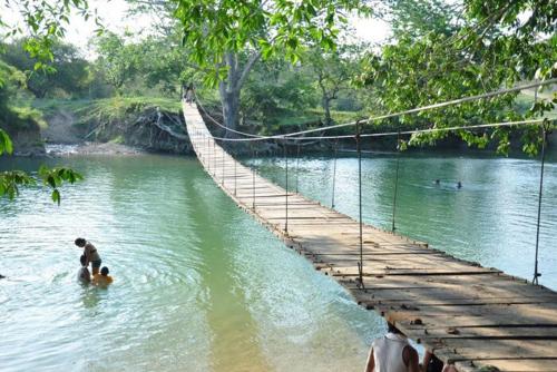 a man standing on a suspension bridge in a river at Vacation Home in San Ignacio, Belize - Sleeps 10 in San Ignacio