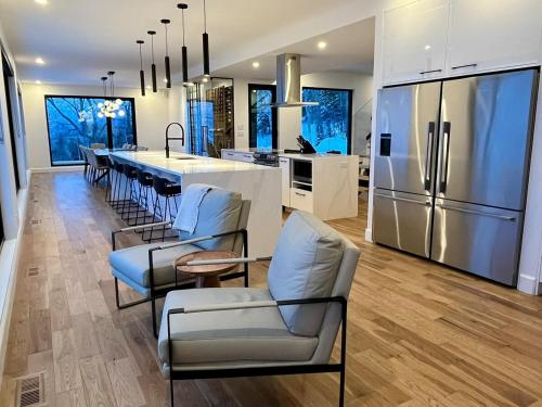 Una cocina con refrigerador y una mesa y sillas. en Le Föss, Fleuve, Sauna & Spa, en Petite-Rivière-Saint-François