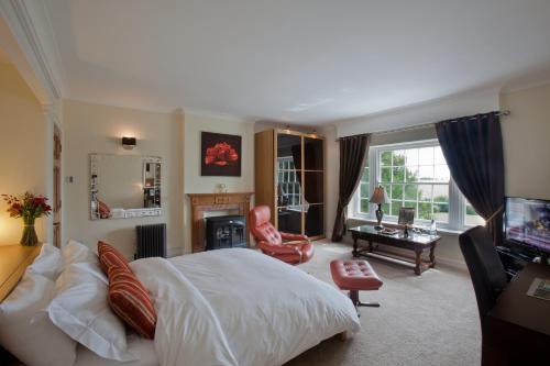 a bedroom with a large bed and a living room at Sturmer Hall Hotel and Conference Centre in Haverhill