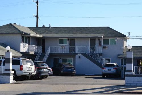 a blue house with cars parked in a parking lot at Villa Las Palmas Motel in Barton Heliport