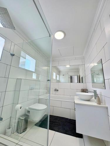 a white bathroom with a toilet and a sink at 175 A on Uniab Close in Langstrand