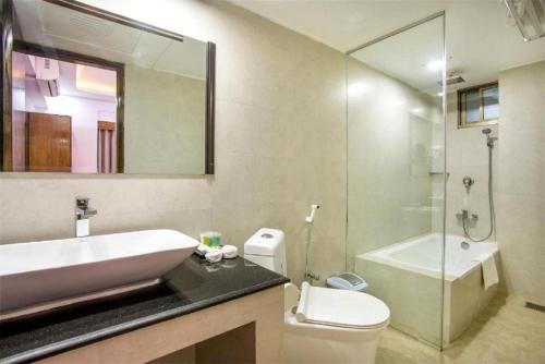 Un baño con lavabo, inodoro y ducha. en Hotel COSTAA LA CAGE Near Delhi Airport BY GROSS GROUP, en Nueva Delhi