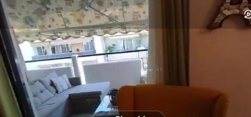 a view of a living room with a couch through a window at Modern 2BR city flat 10min from the beach in Athens