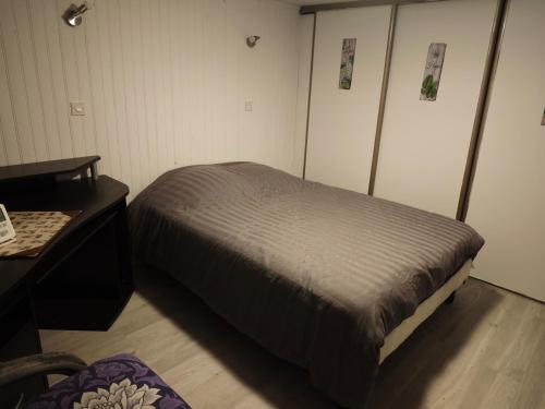 une petite chambre avec un lit et un bureau dans l'établissement Ty Bihan, au Mans