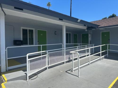 a building with metal railing in a parking lot at Hi-Way Host Motel in Pasadena