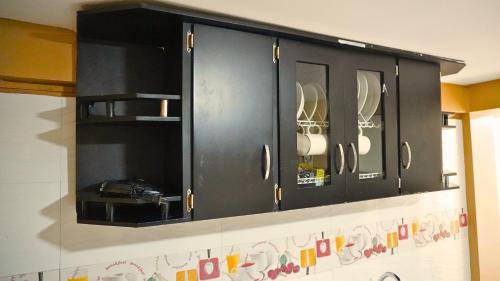 a black cabinet with dishes in it on a wall at Hotel y Cabañas Covemar in Coveñas