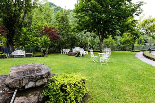 a yard with chairs and a table in the grass at Euroterme in Bagno di Romagna