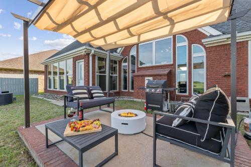 a patio with a grill and a table and chairs at Golf-Side Luxe Escape Sleeps 13 Hot Tub & Theater in Port Arthur