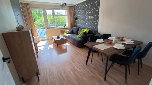 a living room with a table and a couch at Millenium Park Apartment 2-pokojowy in Gdańsk