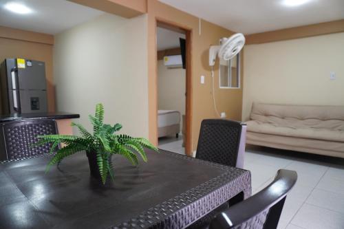 a dining room with a black table with a plant on it at Hotel y Cabañas Covemar in Coveñas