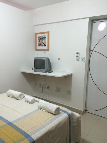 a bedroom with a bed and a tv on a counter at Apartamento Na Ponta Verde in Maceió