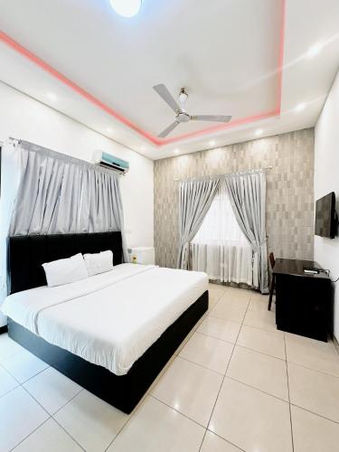 a bedroom with a large white bed and a window at Golden Crystal Hotel in Accra
