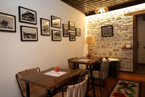 a dining room with two tables and a stone wall at Ador Boutique Hotel in Berat